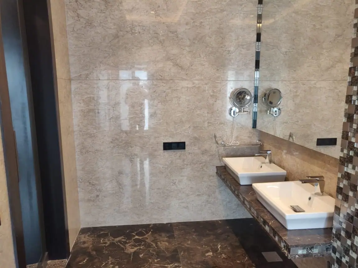 Bathroom with a marble counter, twin basins and a mirrored wall