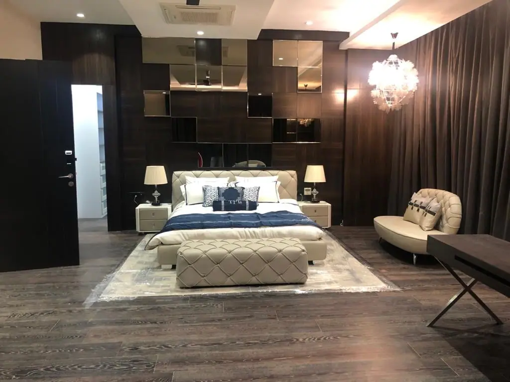 Bedroom with a tufted bed, timber shelving, a chandelier and a study corner