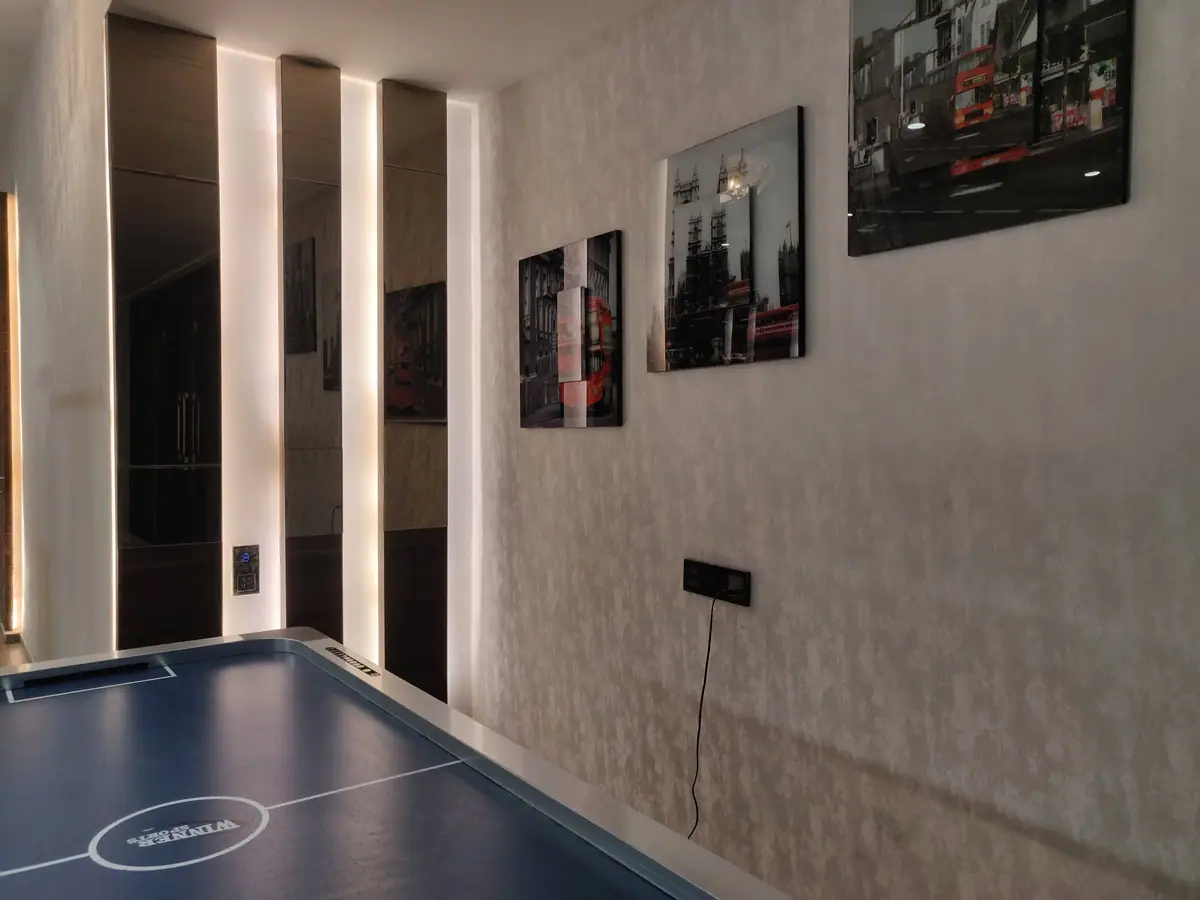Games room with an air-hockey table and a lit timber feature wall