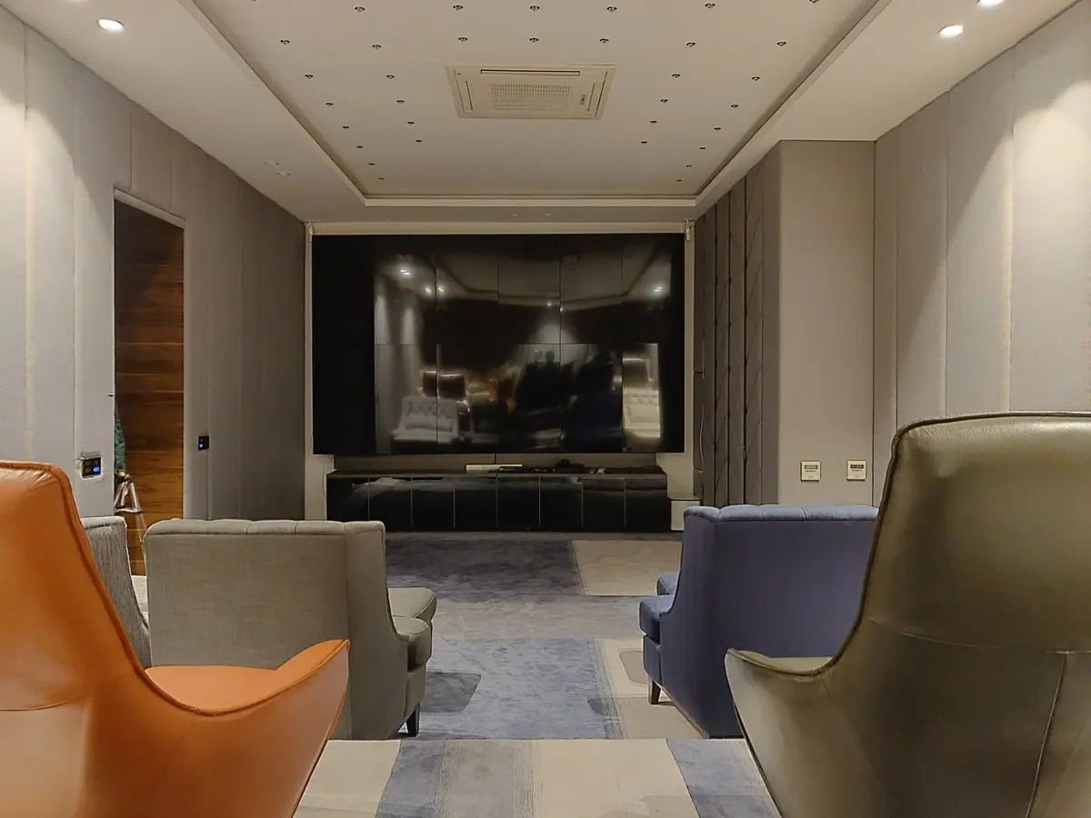 Home theatre with a wall-sized screen and leather armchairs