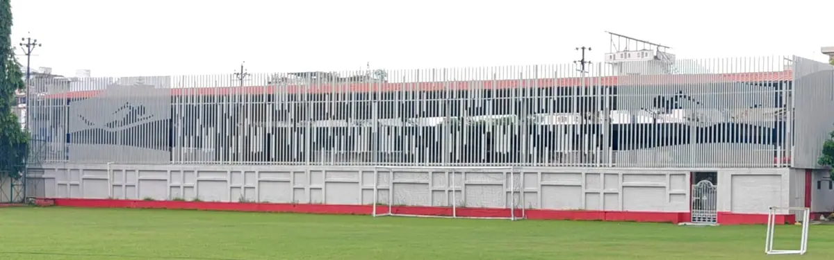 The long MS-tube facade of the Jankipuram pool, with two mirrored swimmer figures carved by cut tubes