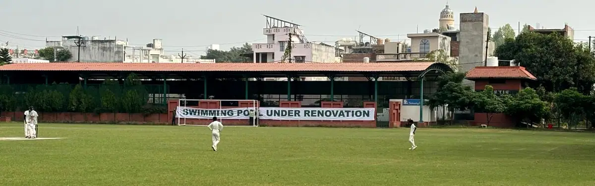 Before: the old open shed with a 'Swimming pool under renovation' banner beside the playing field