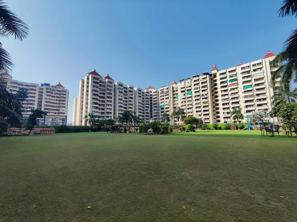 Wide view of the towers and lawn framed by palms