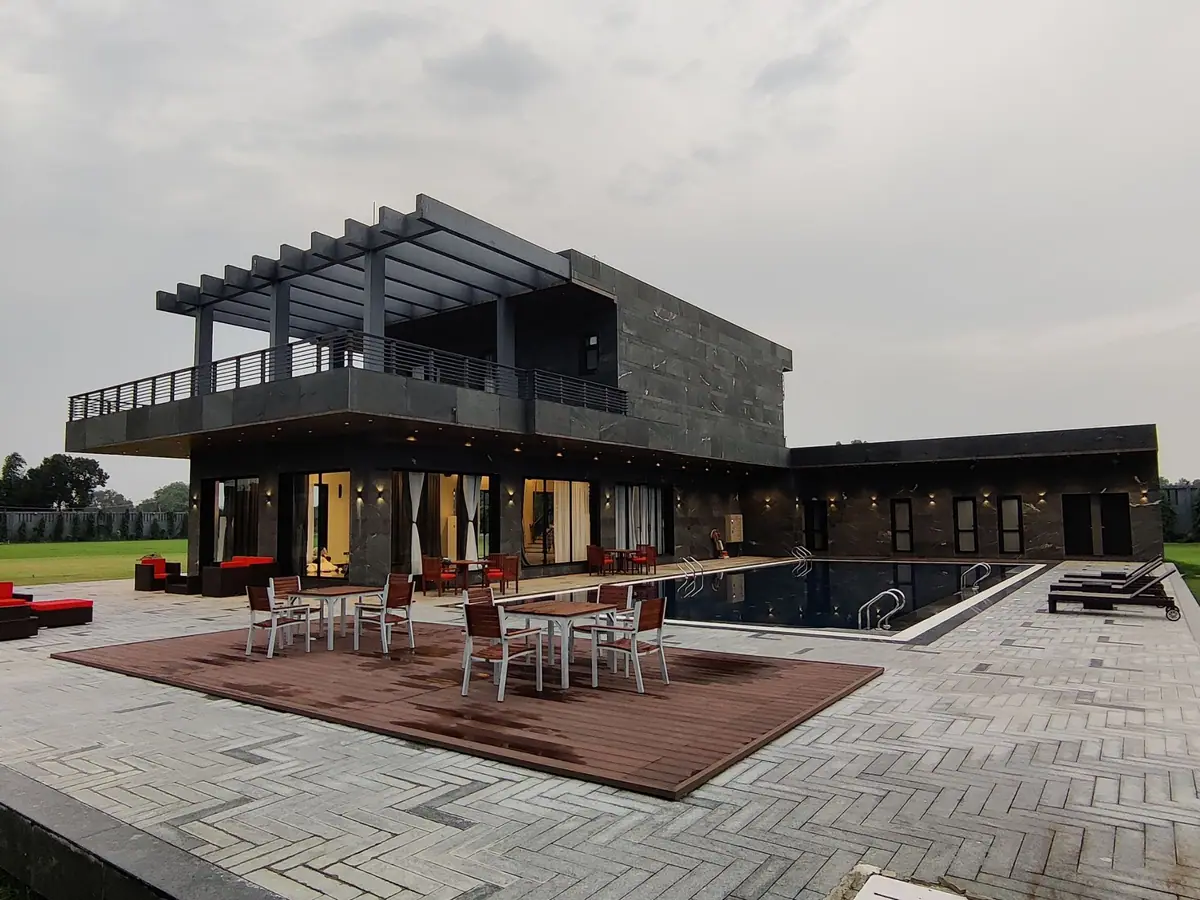 Riviera House at dusk, with the pergola, cantilevered upper floor and lit pool