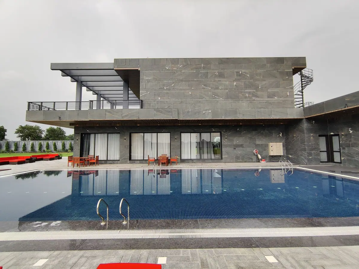 Stone-clad facade reflected in the blue-tiled pool