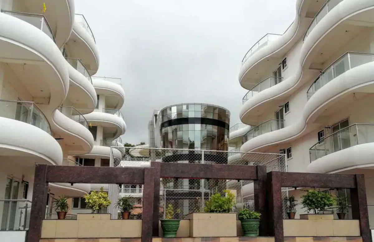 Wave-edged white balconies framing the glass-clad central block
