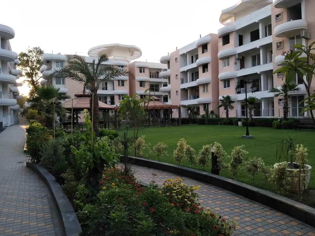 Garden path and lawn with pavilions below the towers at sunset